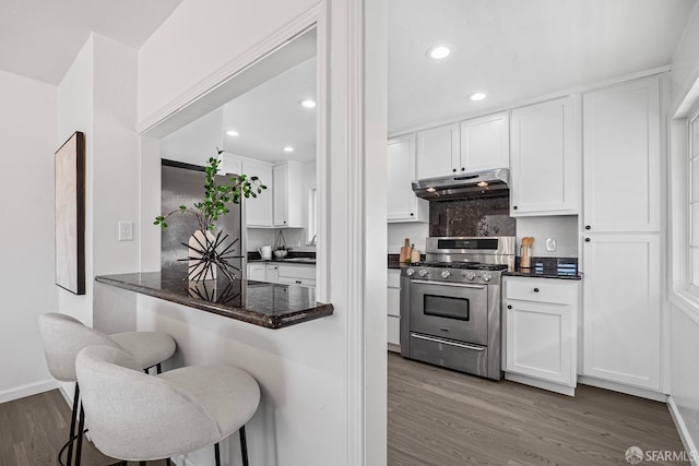 kitchen featuring white cabinetry, a breakfast bar, and stainless steel gas stove