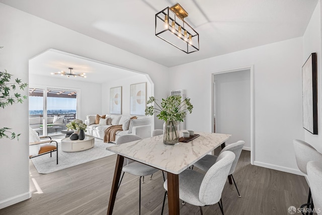 dining area with dark hardwood / wood-style floors and a chandelier