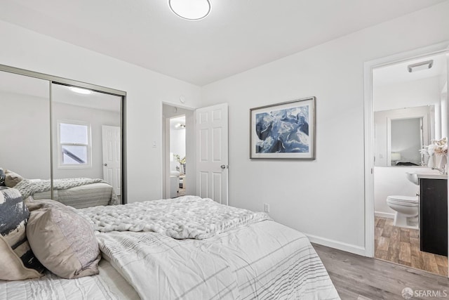 bedroom with hardwood / wood-style floors, ensuite bath, and a closet