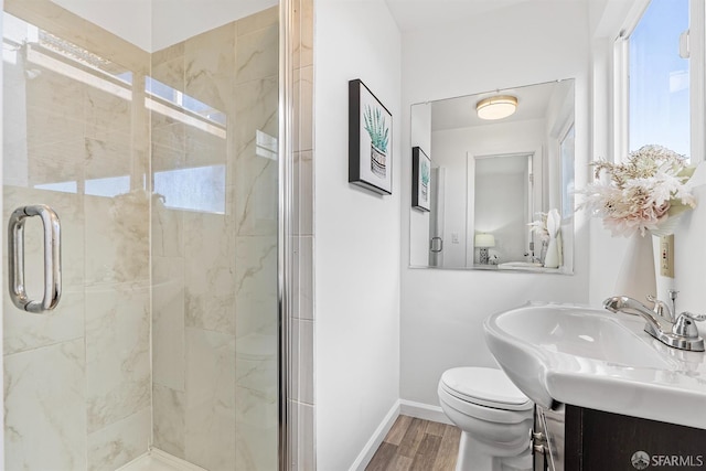 bathroom with vanity, hardwood / wood-style floors, a shower with shower door, and toilet