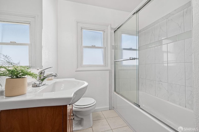 full bathroom featuring vanity, a wealth of natural light, tile patterned floors, and toilet