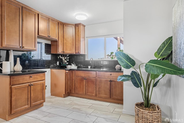 kitchen featuring a healthy amount of sunlight, sink, and backsplash