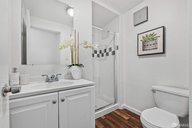 bathroom featuring hardwood / wood-style flooring, vanity, toilet, and walk in shower