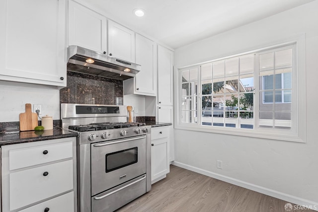 kitchen with gas range, white cabinets, and backsplash