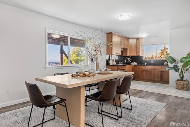 interior space with a wealth of natural light, backsplash, a kitchen bar, and light hardwood / wood-style flooring