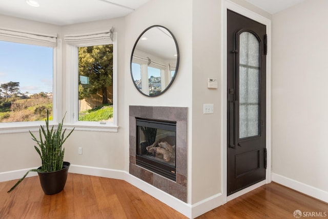 entryway with hardwood / wood-style floors and a fireplace