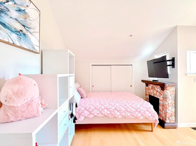 1951 Ofarrell St Unit 420, San Mateo, CA 94403 - bedroom with vaulted ceiling, wood finished floors, a closet, and a fireplace