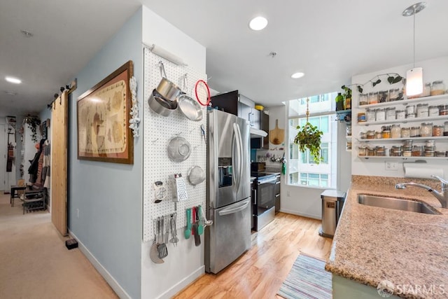 kitchen featuring light wood finished floors, appliances with stainless steel finishes, open shelves, a sink, and recessed lighting