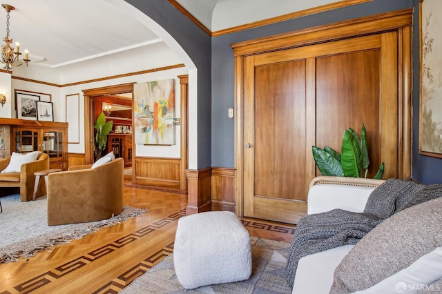 3011 Van Ness Ave, San Francisco, CA 94109 - living area featuring arched walkways, wainscoting, a chandelier, and ornamental molding