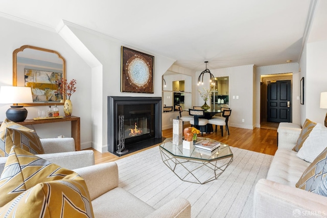 1340 Clay St Unit 302, San Francisco, CA 94109 - living room with wood finished floors, a glass covered fireplace, crown molding, and a chandelier