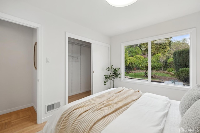 bedroom featuring a closet and light parquet flooring