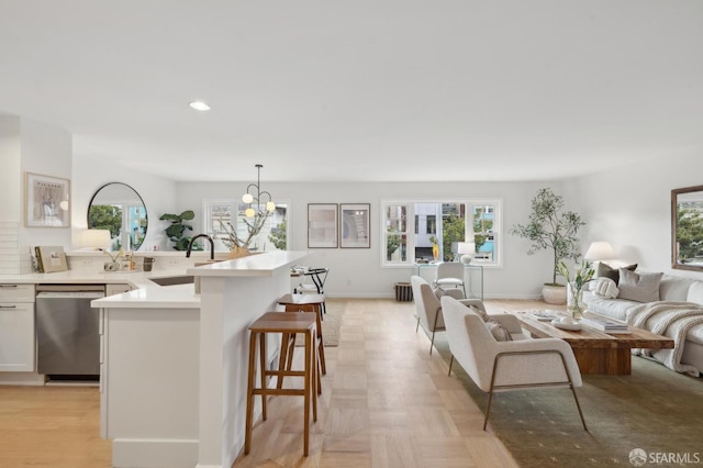 living room featuring sink, a wealth of natural light, and a chandelier