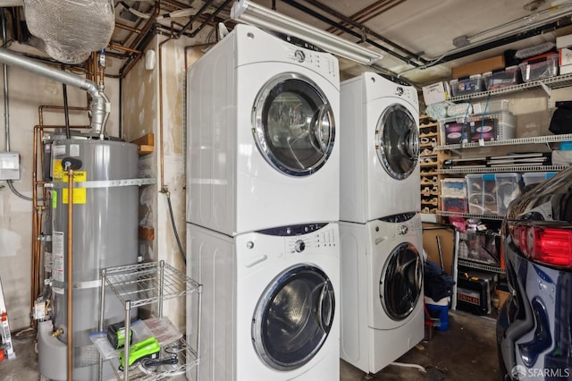 laundry room featuring strapped water heater and stacked washer / dryer