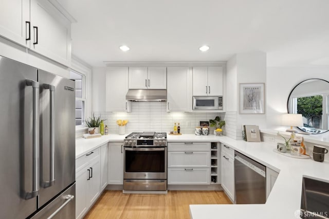 kitchen featuring white cabinetry, decorative backsplash, light hardwood / wood-style floors, and appliances with stainless steel finishes