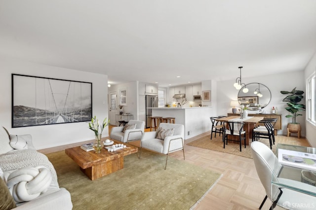 living room with an inviting chandelier and light parquet floors