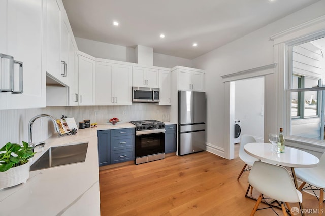 291 Church St, San Francisco, CA 94114 - kitchen featuring appliances with stainless steel finishes, white cabinets, backsplash, light wood-style flooring, and recessed lighting