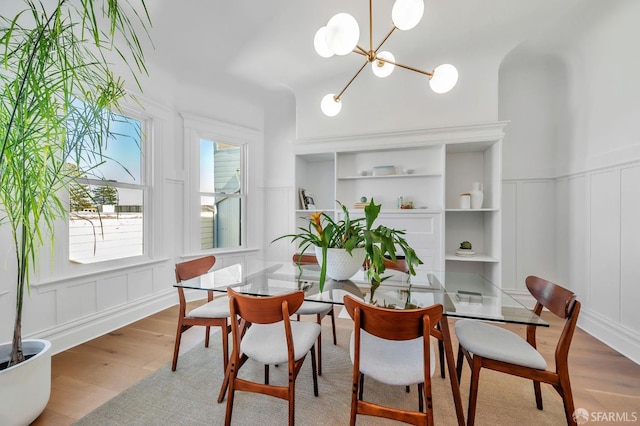 291 Church St, San Francisco, CA 94114 - dining space featuring a decorative wall, wood finished floors, a chandelier, a wainscoted wall, and built in shelves