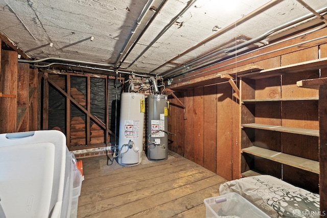 basement featuring water heater and wood-type flooring