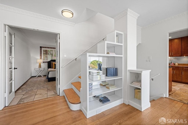 stairs with baseboards, ornamental molding, and wood finished floors