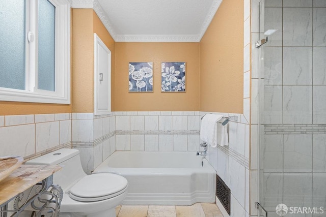 bathroom featuring a garden tub, crown molding, tile walls, and toilet