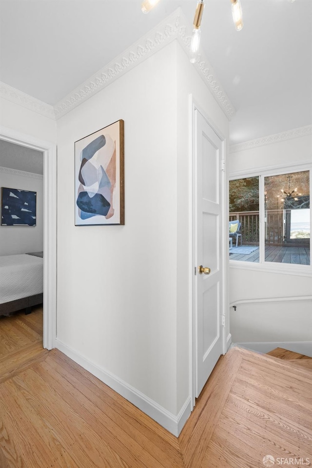 corridor featuring light wood finished floors and baseboards