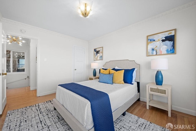 bedroom with baseboards, wood finished floors, and ornamental molding