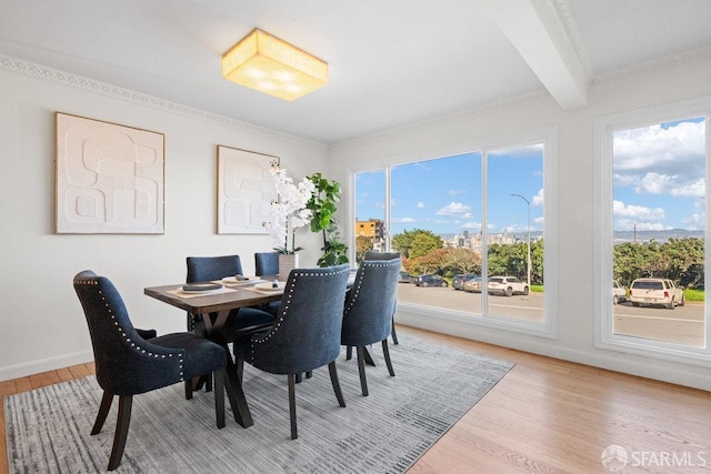 dining area with baseboards, wood finished floors, and beamed ceiling