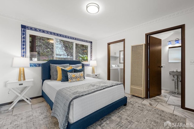 bedroom featuring marble finish floor, baseboards, washer and clothes dryer, and ensuite bathroom