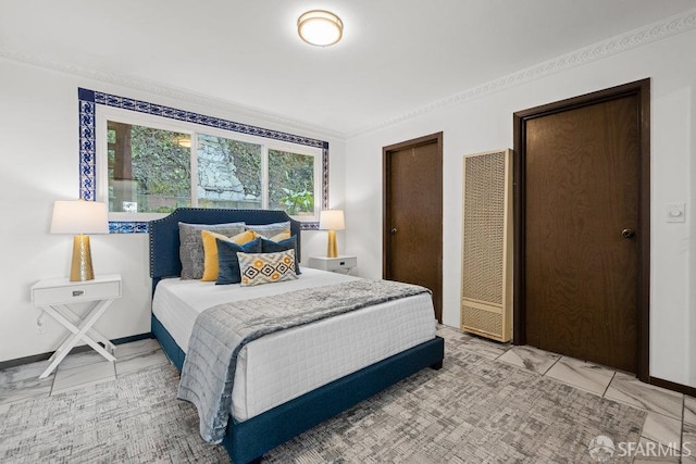 bedroom with marble finish floor, a heating unit, baseboards, and two closets