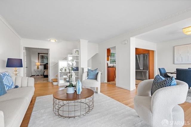 living room with light wood-type flooring, crown molding, stairway, and baseboards