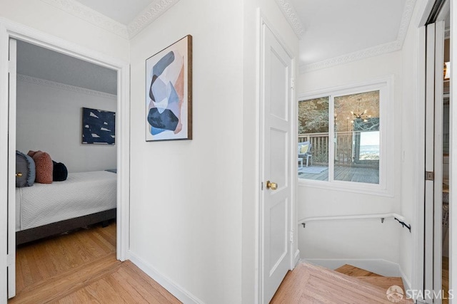 hallway featuring parquet floors, ornamental molding, and baseboards