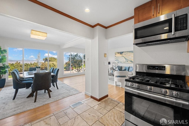 kitchen with plenty of natural light, visible vents, stainless steel appliances, and crown molding