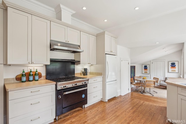 kitchen with stainless steel gas stove, light countertops, light wood-style flooring, freestanding refrigerator, and under cabinet range hood