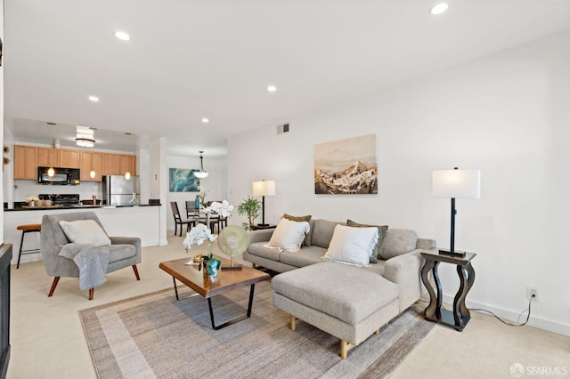 living area with light carpet, baseboards, visible vents, and recessed lighting