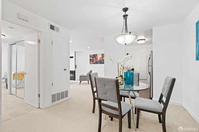 dining space with visible vents, light carpet, and baseboards