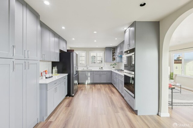 1475 Monterey Blvd, San Francisco, CA 94127 - kitchen featuring gray cabinets, arched walkways, light wood finished floors, stainless steel appliances, and recessed lighting