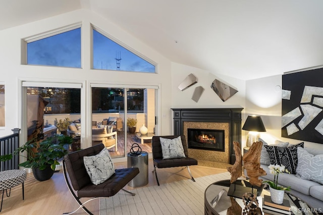 living room with a fireplace, light hardwood / wood-style floors, and lofted ceiling