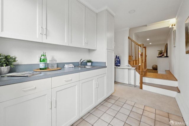 kitchen featuring a sink, light tile patterned floors, light carpet, recessed lighting, and white cabinetry