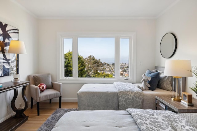 bedroom with baseboards, multiple windows, ornamental molding, and wood finished floors