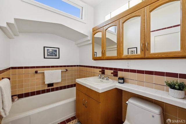 full bathroom featuring toilet, a washtub, wainscoting, and vanity