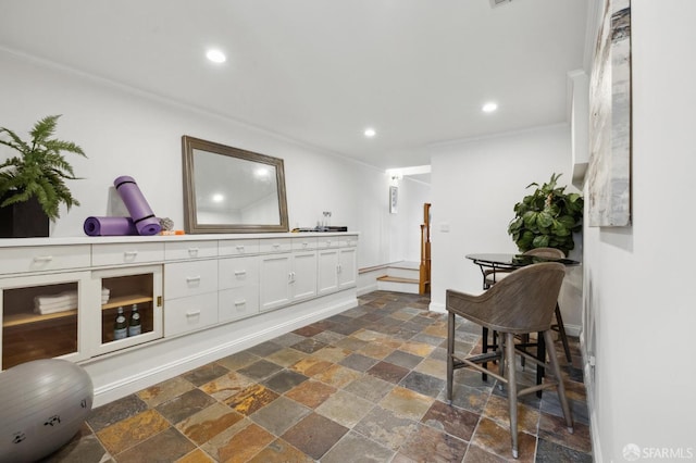 interior space with crown molding, stone tile floors, baseboards, and recessed lighting