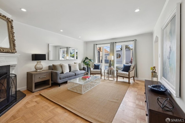 living room featuring crown molding, a fireplace with raised hearth, baseboards, and recessed lighting