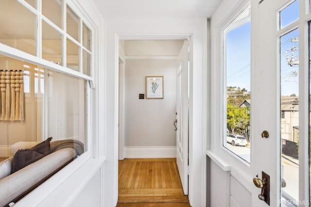 doorway to outside with hardwood / wood-style flooring and crown molding