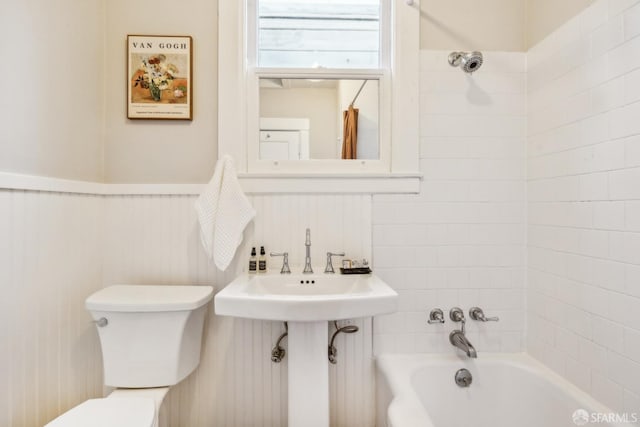 bathroom with tiled shower / bath combo and toilet