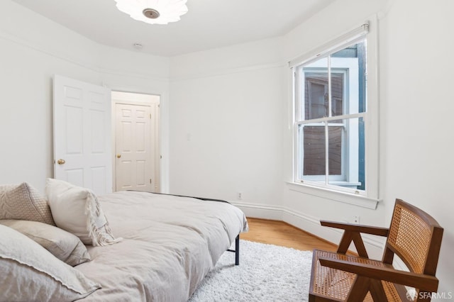 bedroom with wood-type flooring and multiple windows