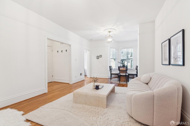 living room featuring wood-type flooring and a chandelier