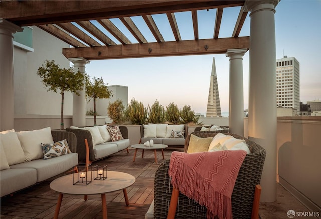 patio terrace at dusk featuring an outdoor living space, a deck, and a pergola