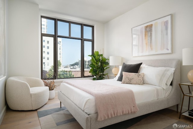 bedroom with wood-type flooring and multiple windows