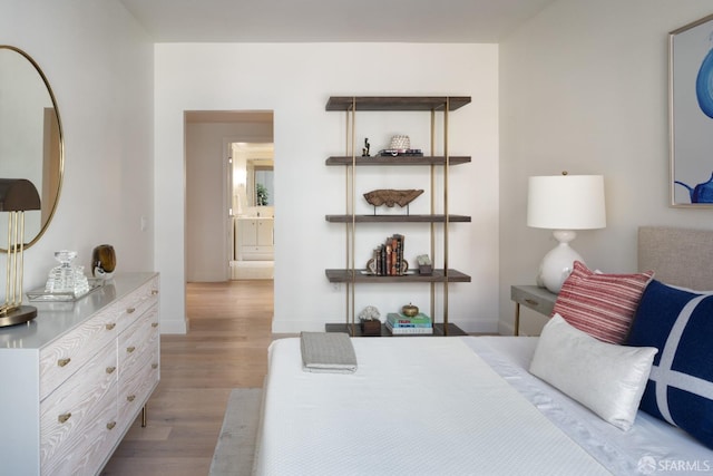 bedroom with light hardwood / wood-style flooring and connected bathroom