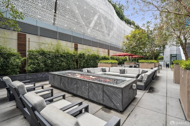 view of patio with an outdoor living space with a fire pit
